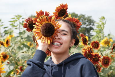 Portrait of smiling woman with sunflower