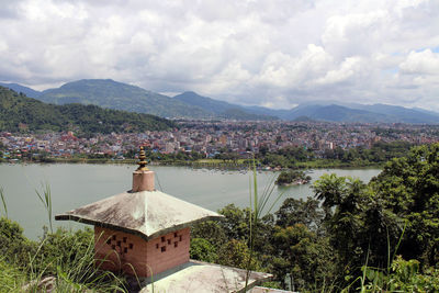 Scenic view of townscape by mountains against sky