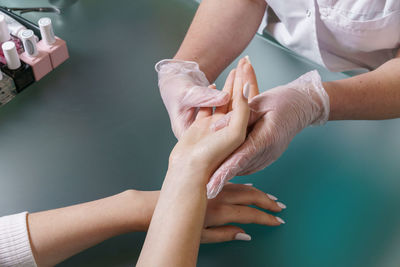 Manicurist does professional light hand massage after manicure procedure.