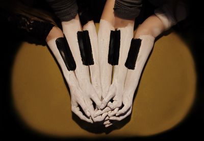 High angle view of painted hands over green background representing unity