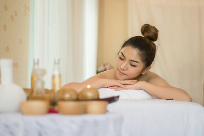 Young woman lying on massage table in spa