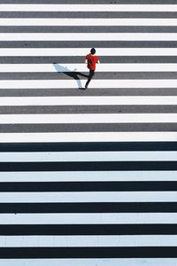 High angle view of man running on zebra crossing