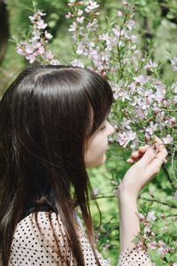 Close-up of beautiful young woman smelling flowers