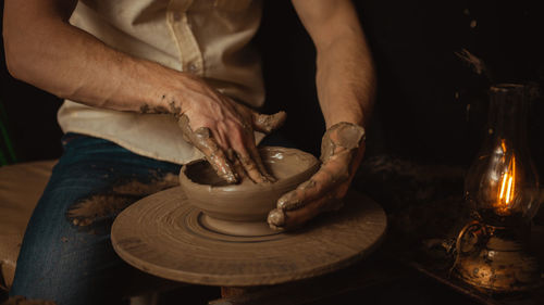 Man makes plate in pottery workshop, clay product, authentic atmosphere, background. lifestyle