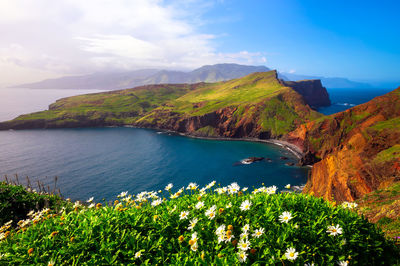 Scenic view of sea and mountains against sky