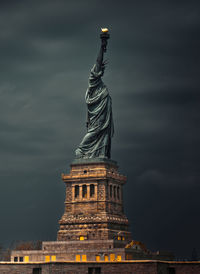 Standing tall - statue of liberty. low angle view of statue against cloudy sky.