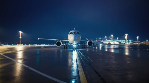 Airplane moving on runway against sky at night
