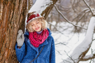 Portrait of smiling young woman standing on snow