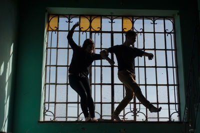 Low angle view of woman looking through window