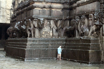 Rear view of man statue in front of historical building