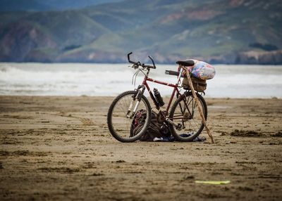 Bicycle on beach against sea