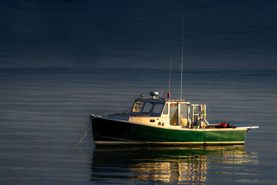 Fishing boat sailing in sea against sky