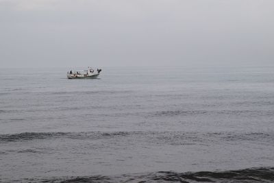 Boat sailing on sea against sky
