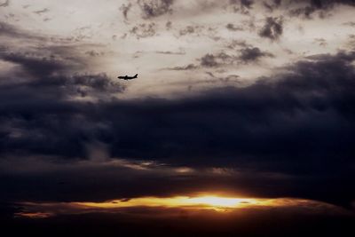 Low angle view of silhouette airplane flying in sky