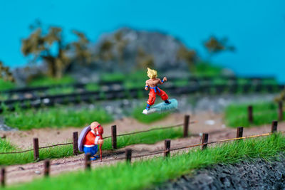 Close-up of stuffed toy on land against blue sky