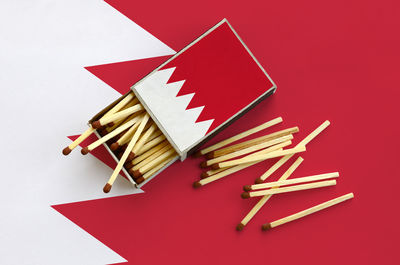 High angle view of colored pencils on table against red background