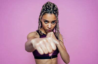 Portrait of woman with pink hair against colored background