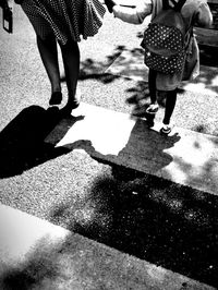 Low section of woman standing on footpath