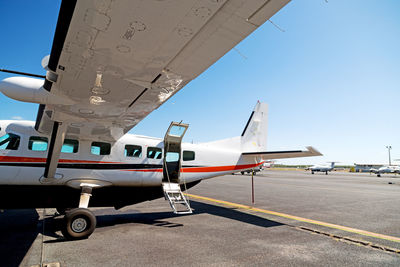 Airplane on airport runway against sky