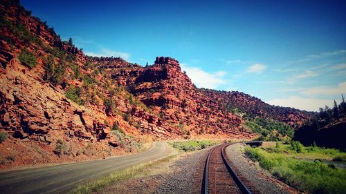 Road by mountain against sky