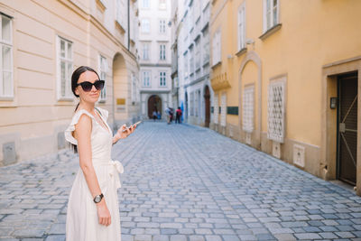 Portrait of young woman standing in city