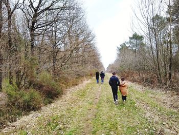 Rear view of people walking on footpath