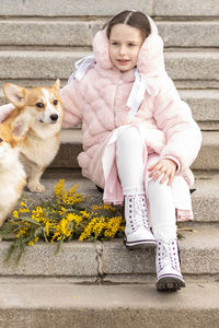 Toddler girl with corgi dogs in the park.  spring, international women's day march 8