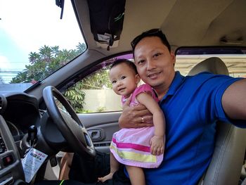 Portrait of mother and daughter while sitting in car