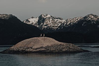 Scenic view of lake by mountains against sky