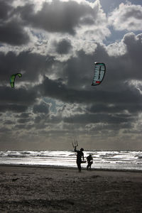 People on beach by sea against sky