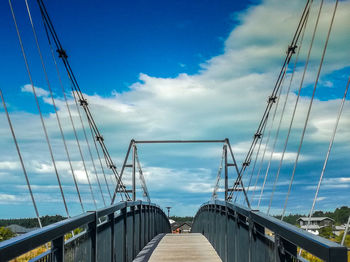 Low angle view of suspension bridge against sky