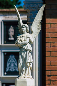 Statue of angel against wall