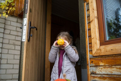 Full length of woman standing against door