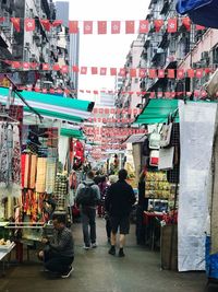 Rear view of people walking on street in city