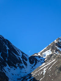 Scenic view of snowcapped mountains against clear blue sky