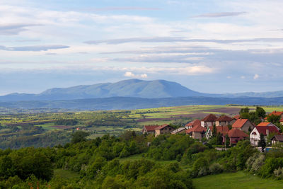 Scenic view of landscape and houses against sky