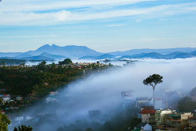 Scenic view of trees and buildings against sky