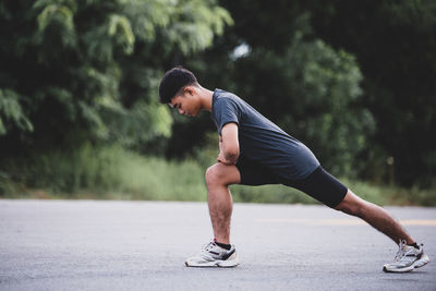 Full length of young man sitting on road