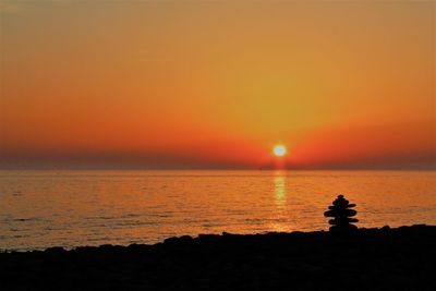 Scenic view of sea against orange sky during sunset