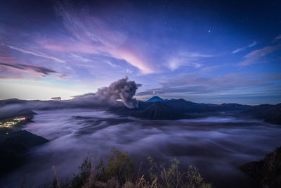 Scenic view of volcanic mountain against sky during sunset