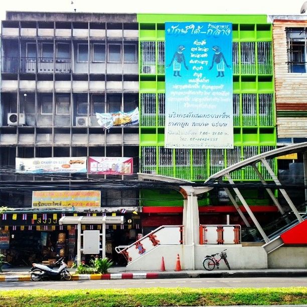 building exterior, architecture, built structure, land vehicle, transportation, mode of transport, city, building, graffiti, text, car, multi colored, bicycle, western script, day, street, window, outdoors, stationary, parked