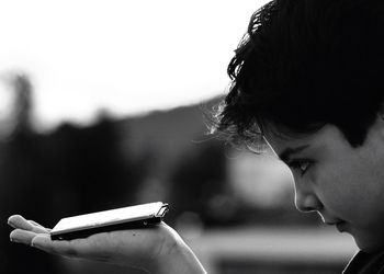 Profile view of curious boy holding hard drive