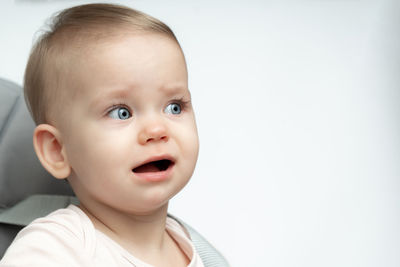 Close-up of cute baby boy against white background