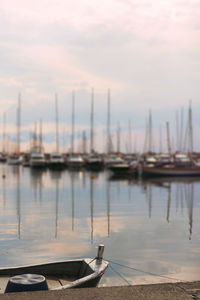 Sailboats moored at harbor against sky