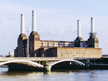 Bridge over river against sky in city