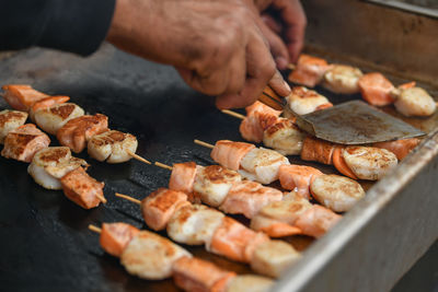 Cropped image of man preparing food on barbecue grill