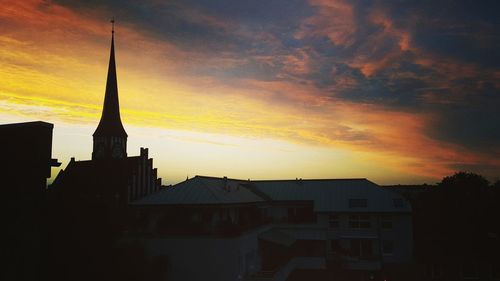 Silhouette city against sky during sunset