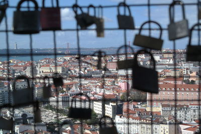 View of padlocks with buildings in background