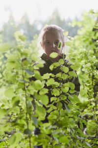 Portrait of cute girl standing amidst plants