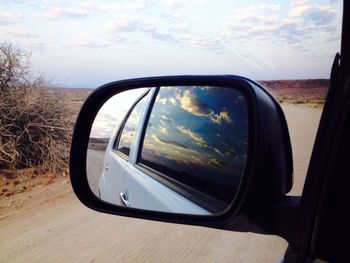 Reflection of clouds in side-view mirror